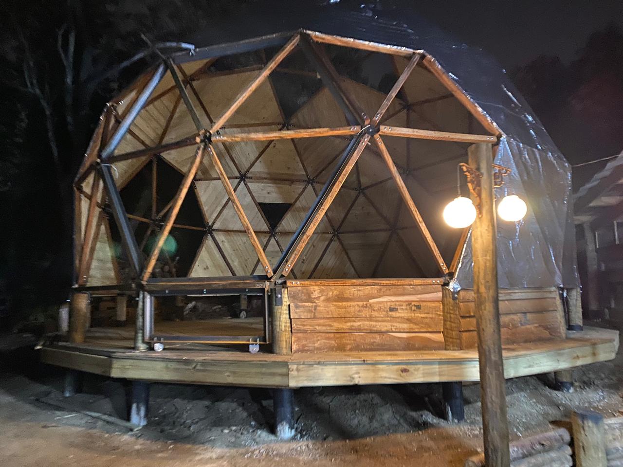 Domo iluminado à noite com estrutura triangular aparente